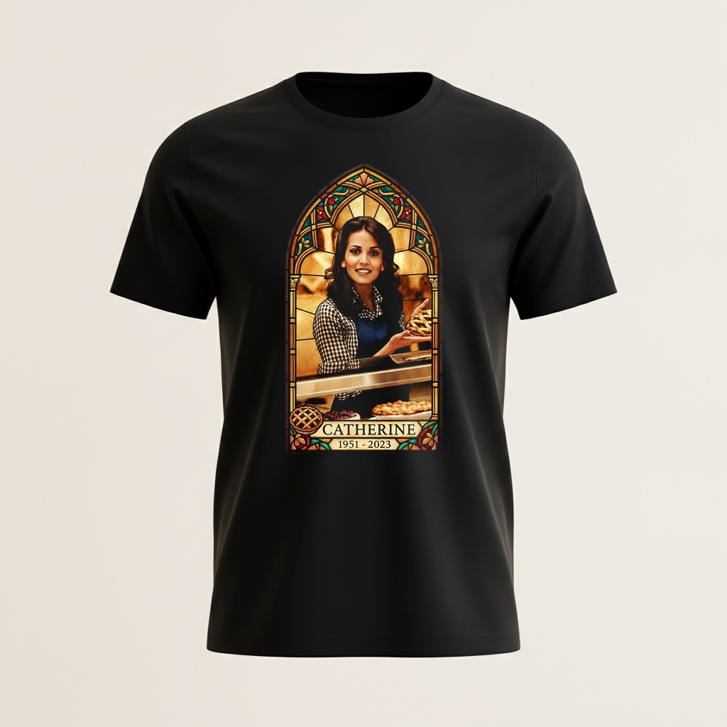 A stained glass memorial shirt honoring Catherine, 1951 to 2023, shown in her bakery holding a pie